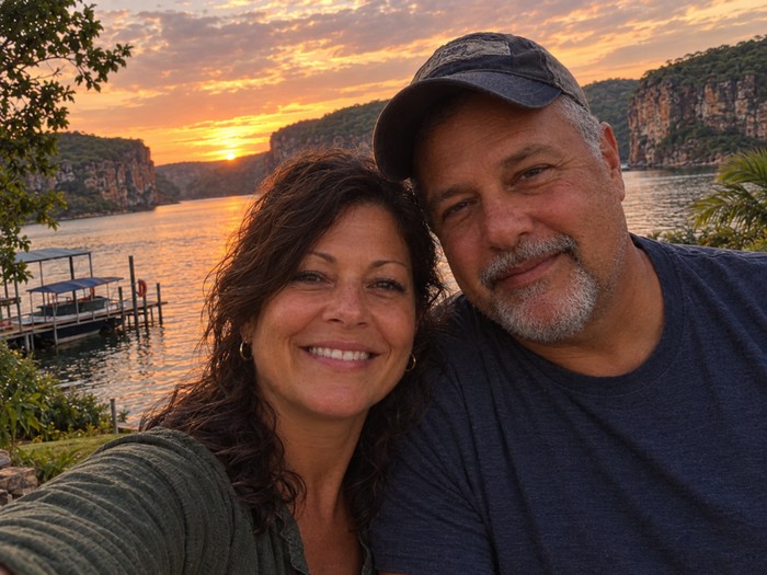 Lúcia e o marido na beira do lago ao pôr do sol